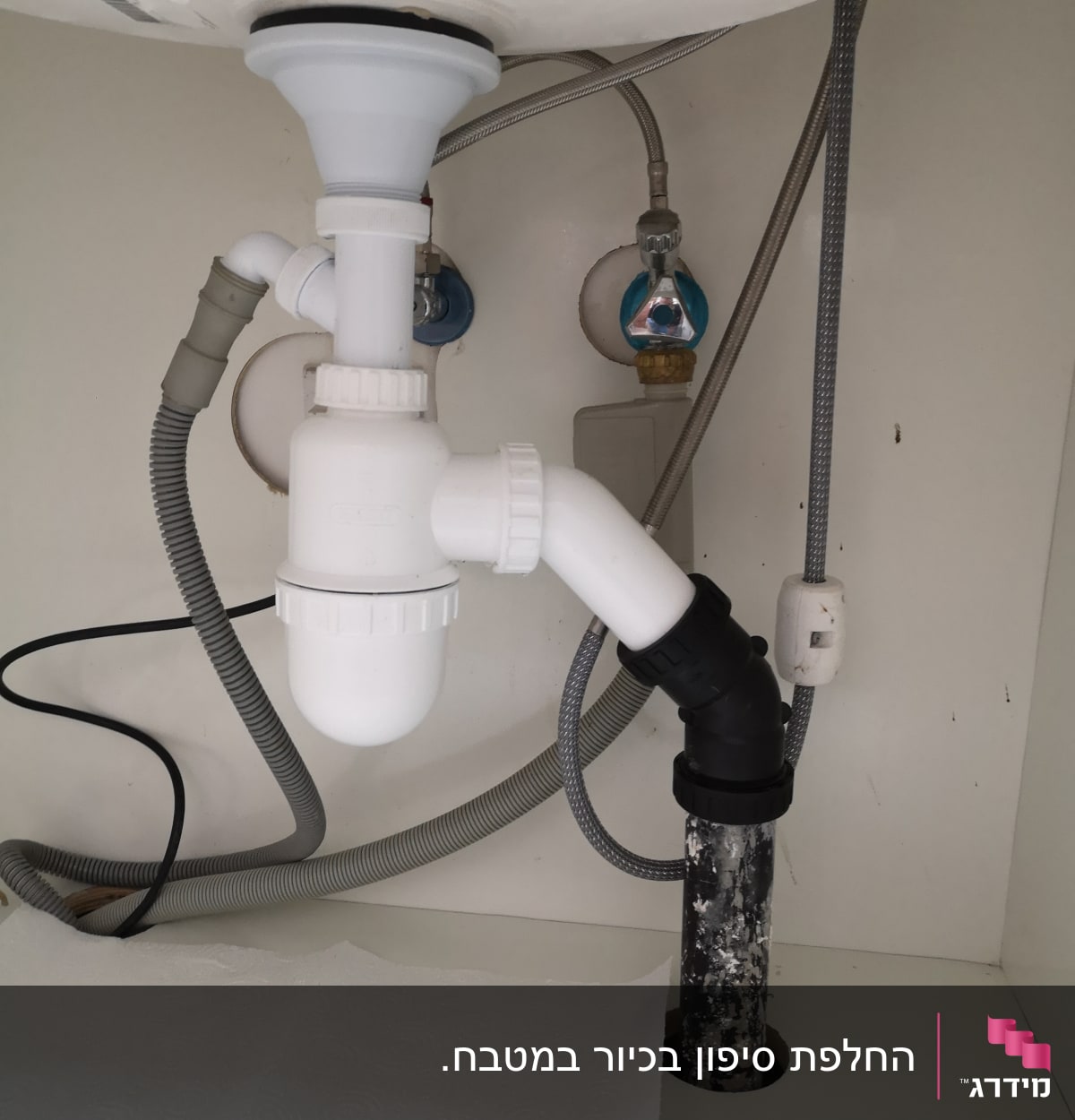 צנרת פלסטיק מתחת לכיור עם ברזים וצינורות